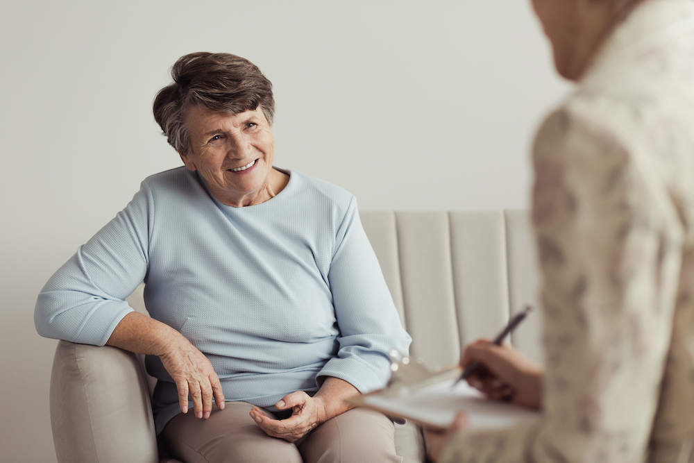Smiling grandmother and financial counselor Woman sitting on couch
